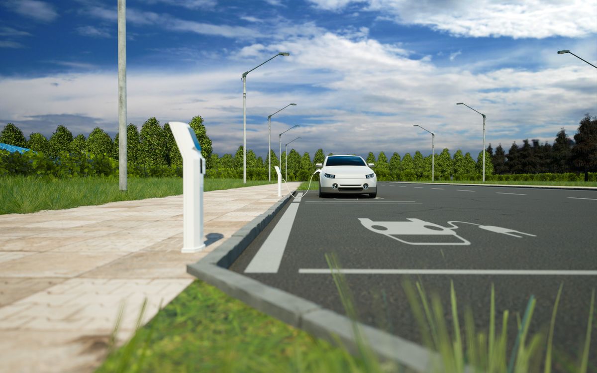 An EV charging at a station in the middle of the road