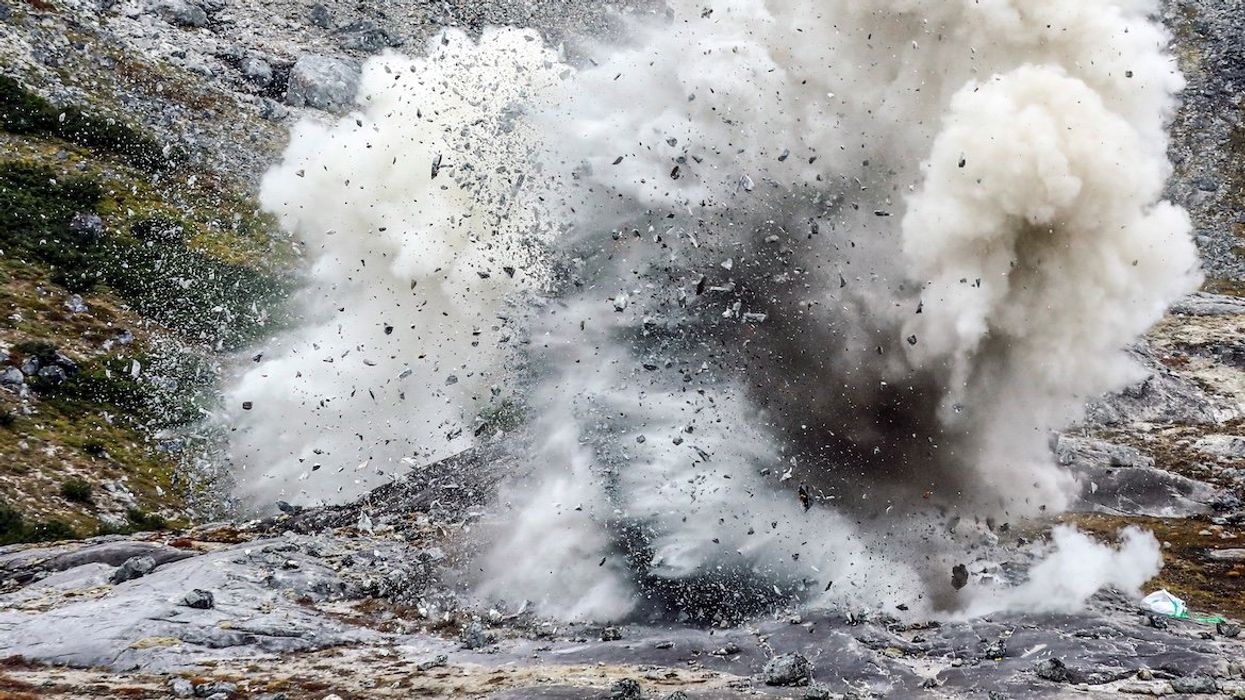 An explosion is pictured at an exploration site of the company Greenland Anorthosite Mining of an anorthosite deposit close to the Qeqertarsuatsiaat fjord, Greenland, on Sept. 11, 2021.