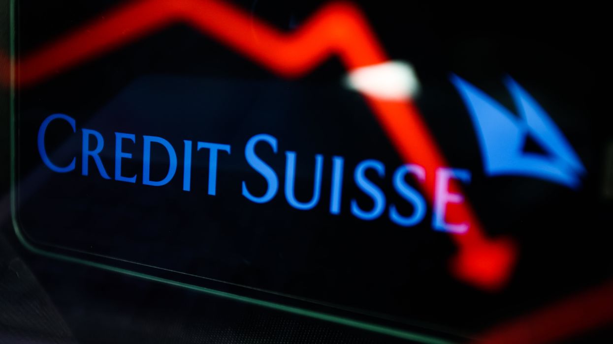 An illustrative stock chart and Credit Suisse logo displayed on a phone screen.