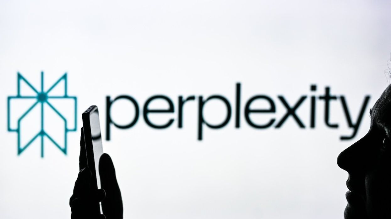 An image of a woman holding a cell phone in front of a Perplexity AI logo displayed on a computer screen.