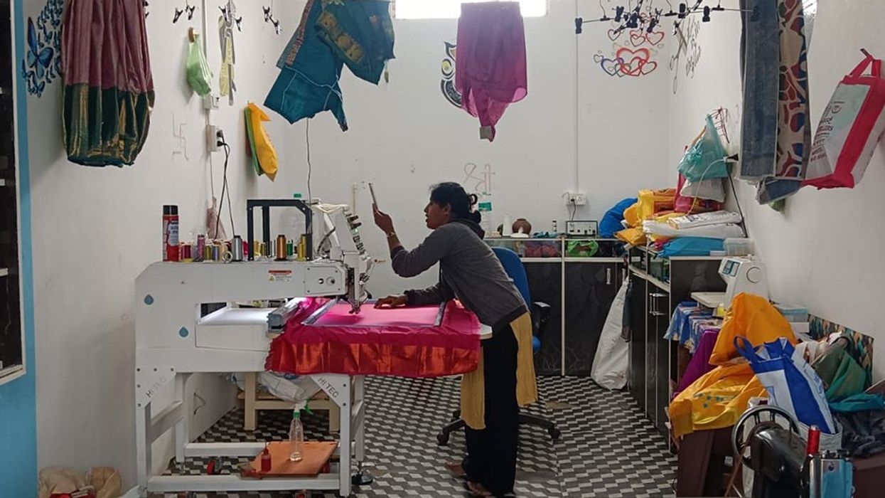 An Indian woman stitching in a fabric shop