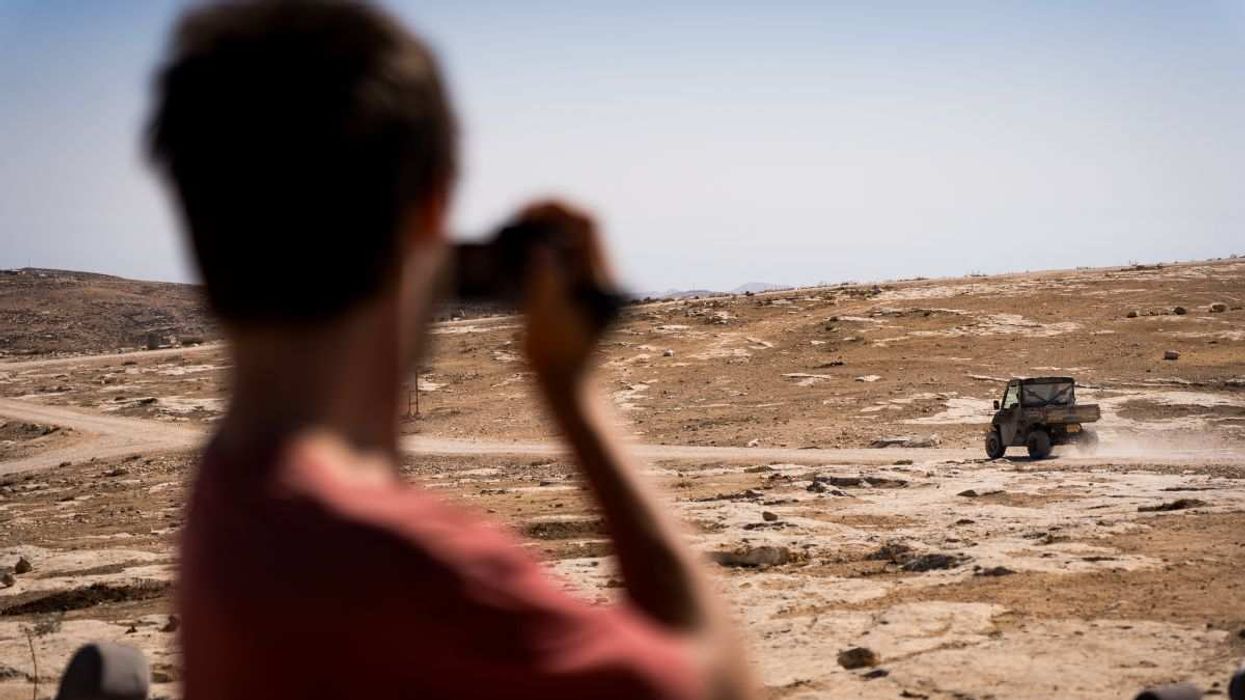 An Israeli activist records illegal settlers driving past a village in Masafer Yatta in the West Bank, on October 28, 2025.
