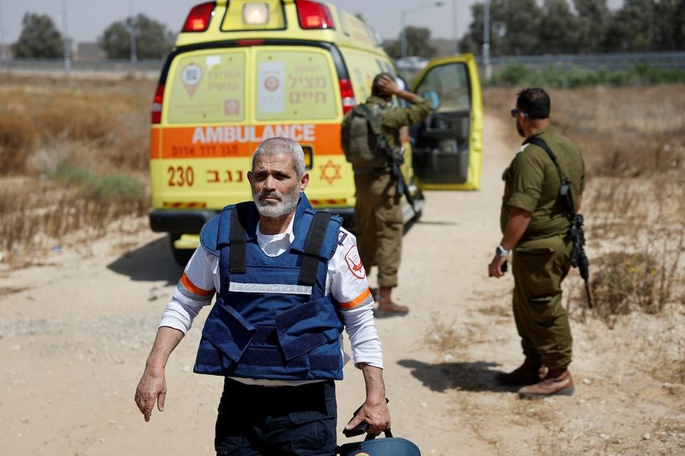 ​An Israeli medic walks near soldiers and an ambulance after Hamas claimed responsibility for an attack on the Kerem Shalom crossing near Israel's border with Gaza in southern Israel, on May 5, 2024.