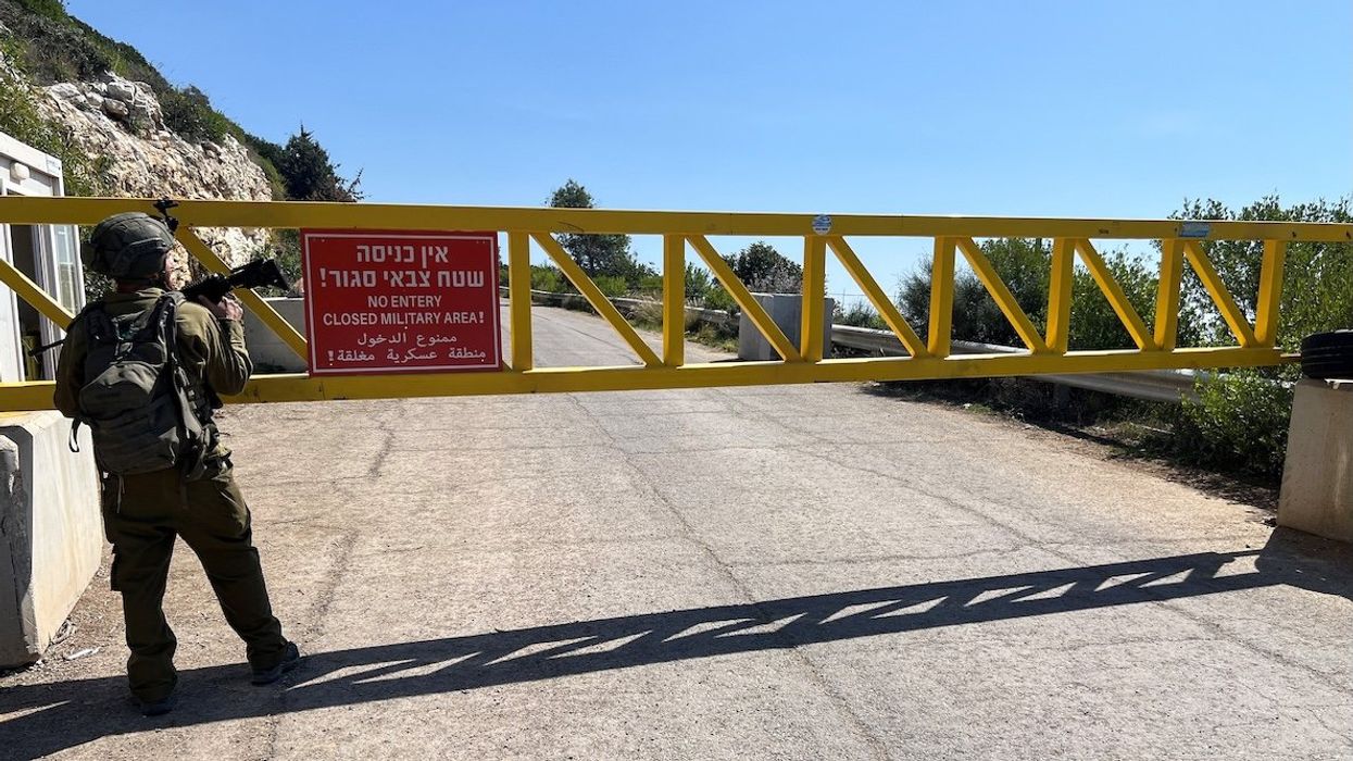 An Israeli soldier stands next to a gate on a road near the Israel-Lebanon border, in Israel, on March 12, 2025.