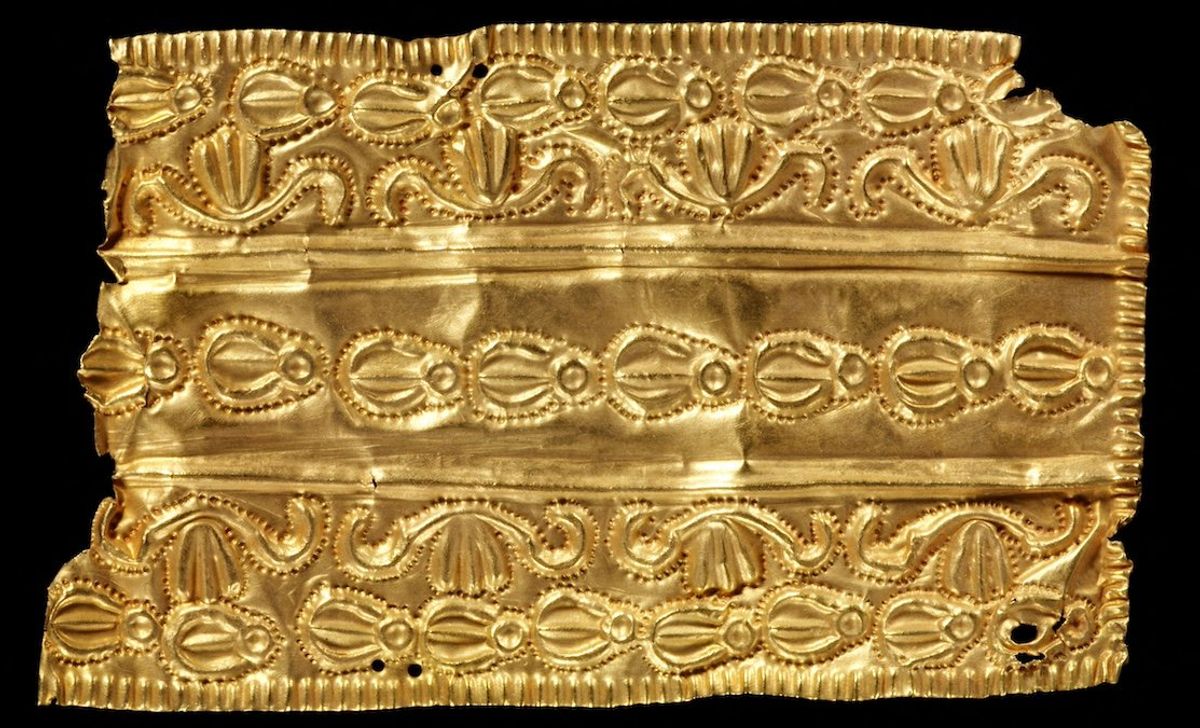 An oblong repousse gold ornament with three bands of decora is displayed in this undated handout picture obtained by Reuters.