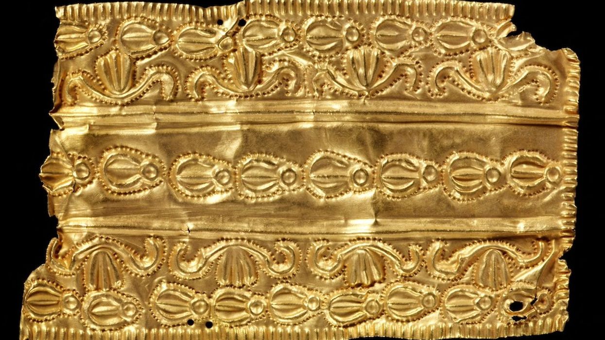 An oblong repousse gold ornament with three bands of decora is displayed in this undated handout picture obtained by Reuters.