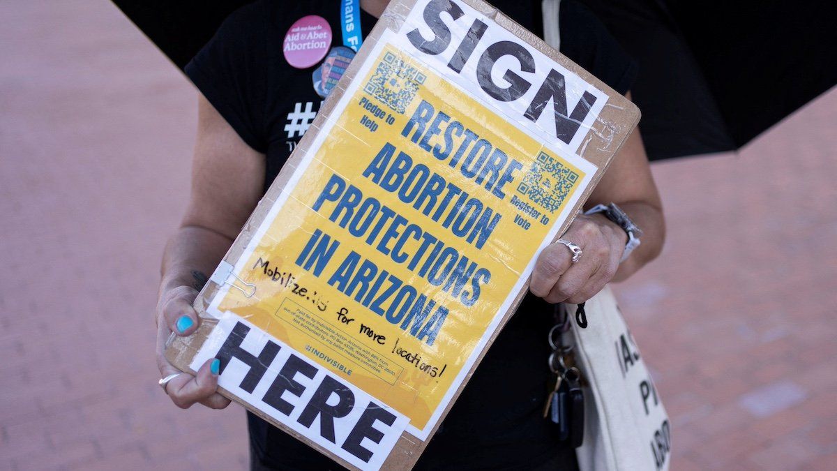 ​An organizer carries a clipboard with petitions for a ballot initiative to enshrine abortion into the Arizona state constitution during a small rally led by Women's March Tucson after Arizona's Supreme Court revived a law dating to 1864 that bans abortion in virtually all instances, in Tucson, Arizona, U.S. April 9, 2024. 