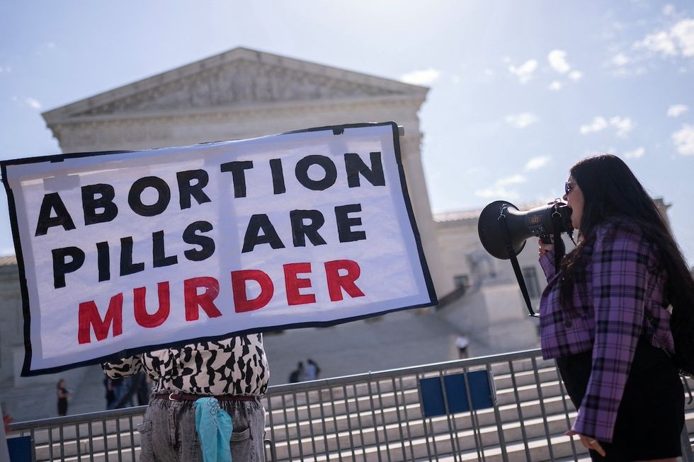 Anti-abortion activists hold signs calling for the Supreme Court justices to "affirm the decision of Federal District Court Judge Matthew Kacsmaryk who suspended the Food and Drug Administration's approval of Mifepristone," in front of the U.S. Supreme Court in Washington, U.S., April 21, 2023.