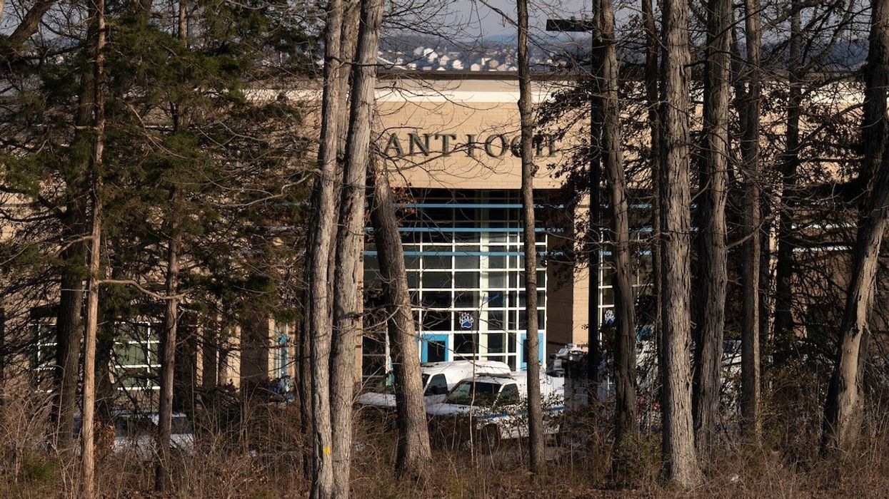 Antioch High School is obscured by trees, but emergency personnel were still onsite after a student shot and killed a girl, injured a boy and later fatally shot himself in the school's cafeteria in Antioch, Tenn., on Jan. 22, 2025.