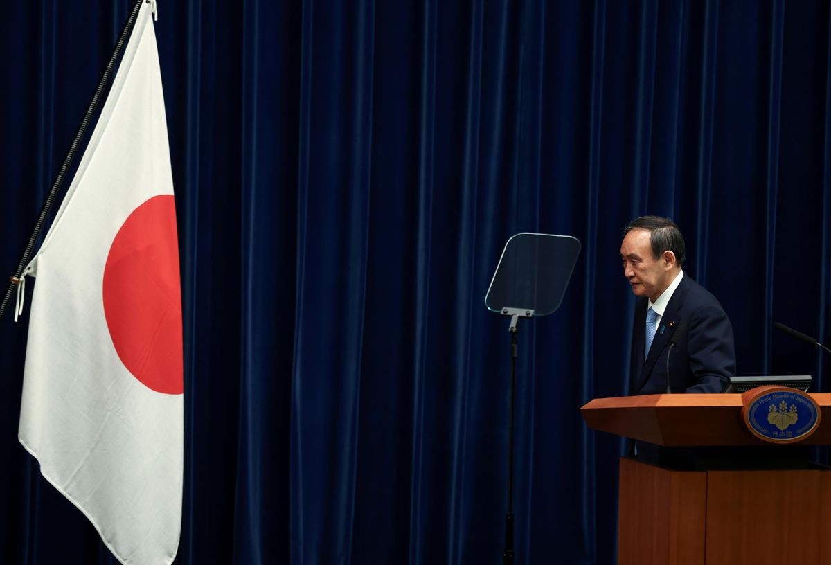 apan's Prime Minister Yoshihide Suga bows in front of the national flag at a news conference after the government's decision to exted a state of emergency amid coronavirus disease (COVID-19) pandemic, at the prime minister's official residence in Tokyo, Japan May 28, 2021