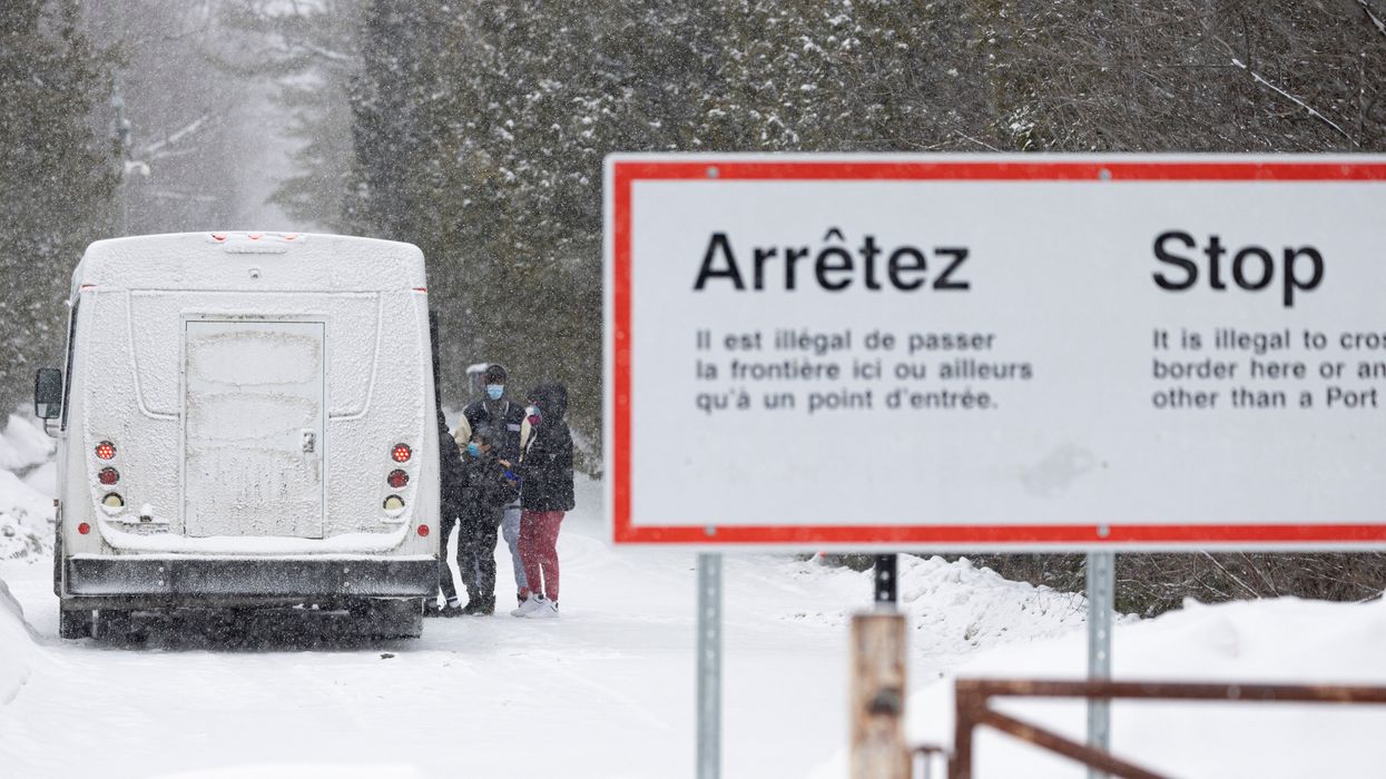 Asylum-seekers board a bus after crossing into Canada from the US in Champlain, New York.