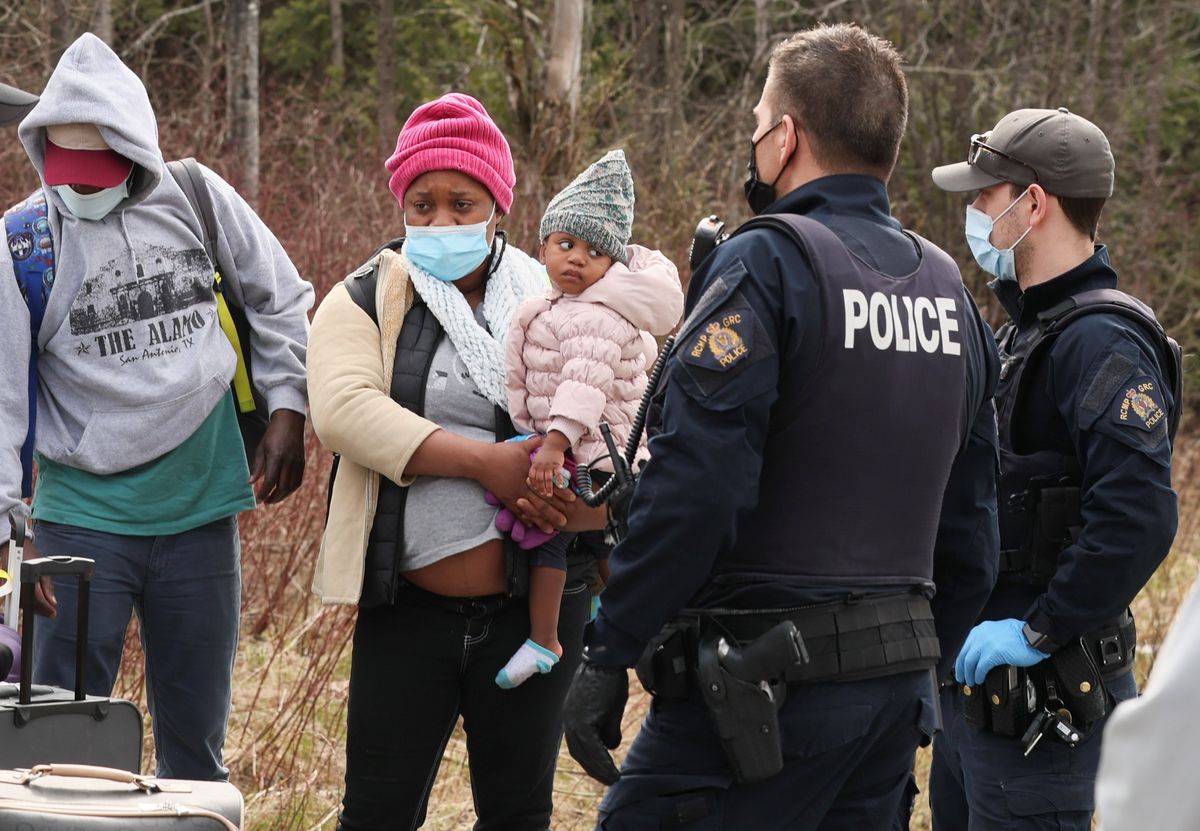 Asylum seekers cross into Canada from the US border near a checkpoint on Roxham Road near Hemmingford, Quebec.