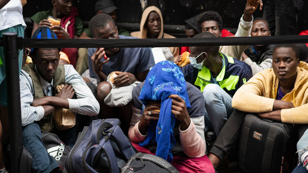 Asylum seekers fill the sidewalk outside of the Roosevelt hotel in midtown Manhattan, New York City.