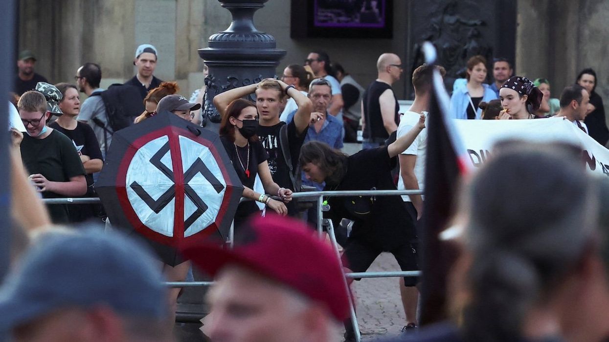 Attendees of Germany's Alternative for Germany (AfD) campaign event for the Saxony state elections leave, as counter protestors stand in the background, in Dresden, Germany, August 29, 2024.