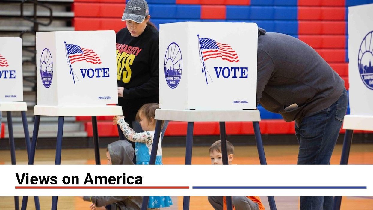 Aubrey and Taylor Endicott cast their votes while their children, from left, Sterling, 5, Adelaide, 3, and Lincoln, 7, wait patiently under the voting tables at Shawnee Heights Middle School on Tuesday, Nov. 5, 2024.