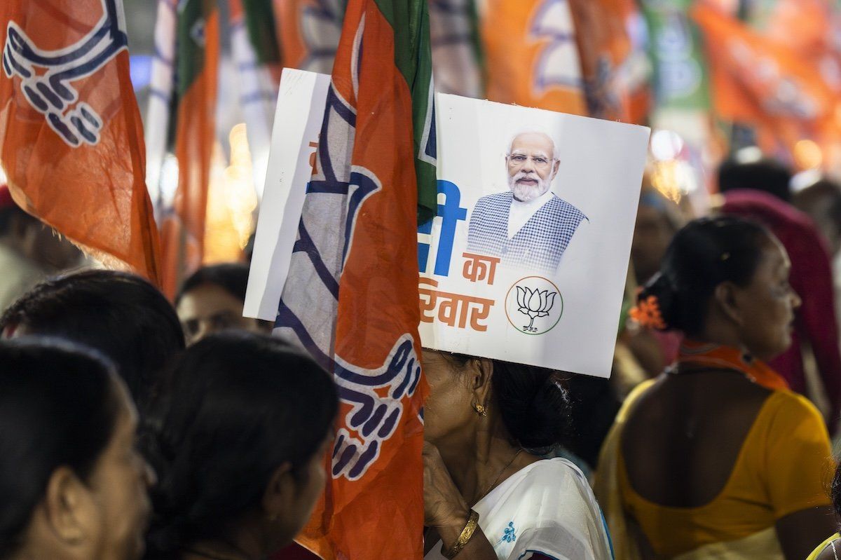 ​Bharatiya Janata Party supporters hold party flags while waiting for Narendra Modi's road show during an election campaign in Guwahati, Assam, India, on April 16, 2024.