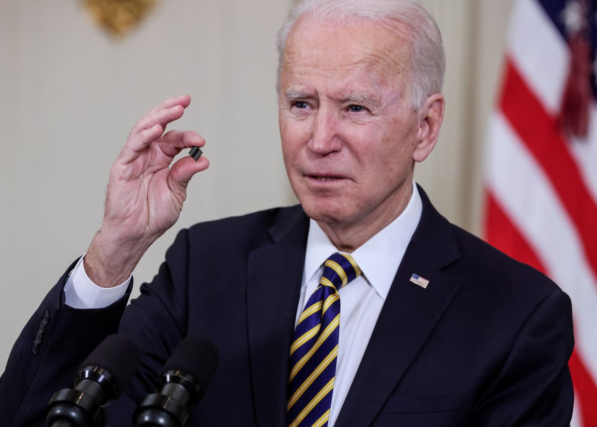 Biden holds a microchip to discuss the strategic importance of semiconductors.