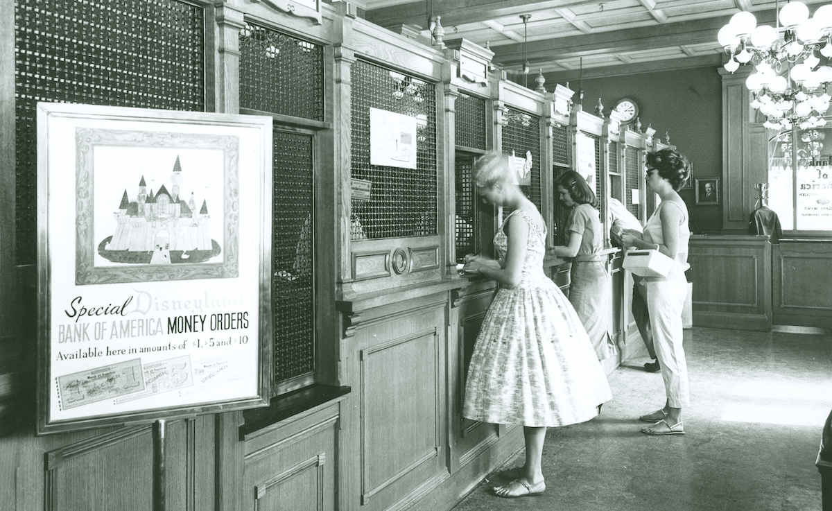 Black and white image of women buying disneyland tickets at the counter
