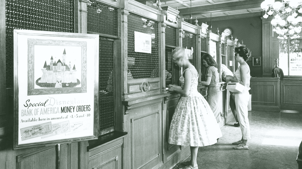 Black and white image of women buying disneyland tickets at the counter