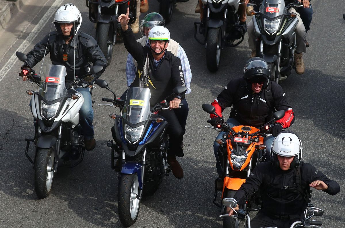 Brazil's President Jair Bolsonaro gestures to his supporters as he leads a motorcade, amid the coronavirus disease (COVID-19) pandemic, to the National Monument to the Dead of World War II in Rio de Janeiro, Brazil May 23, 2021.