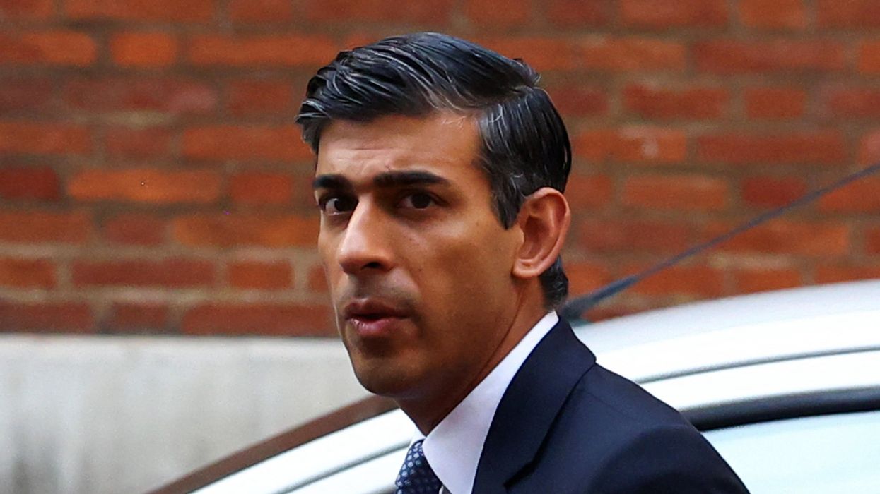 British PM candidate Rishi Sunak walks next to his campaign headquarters in London.
