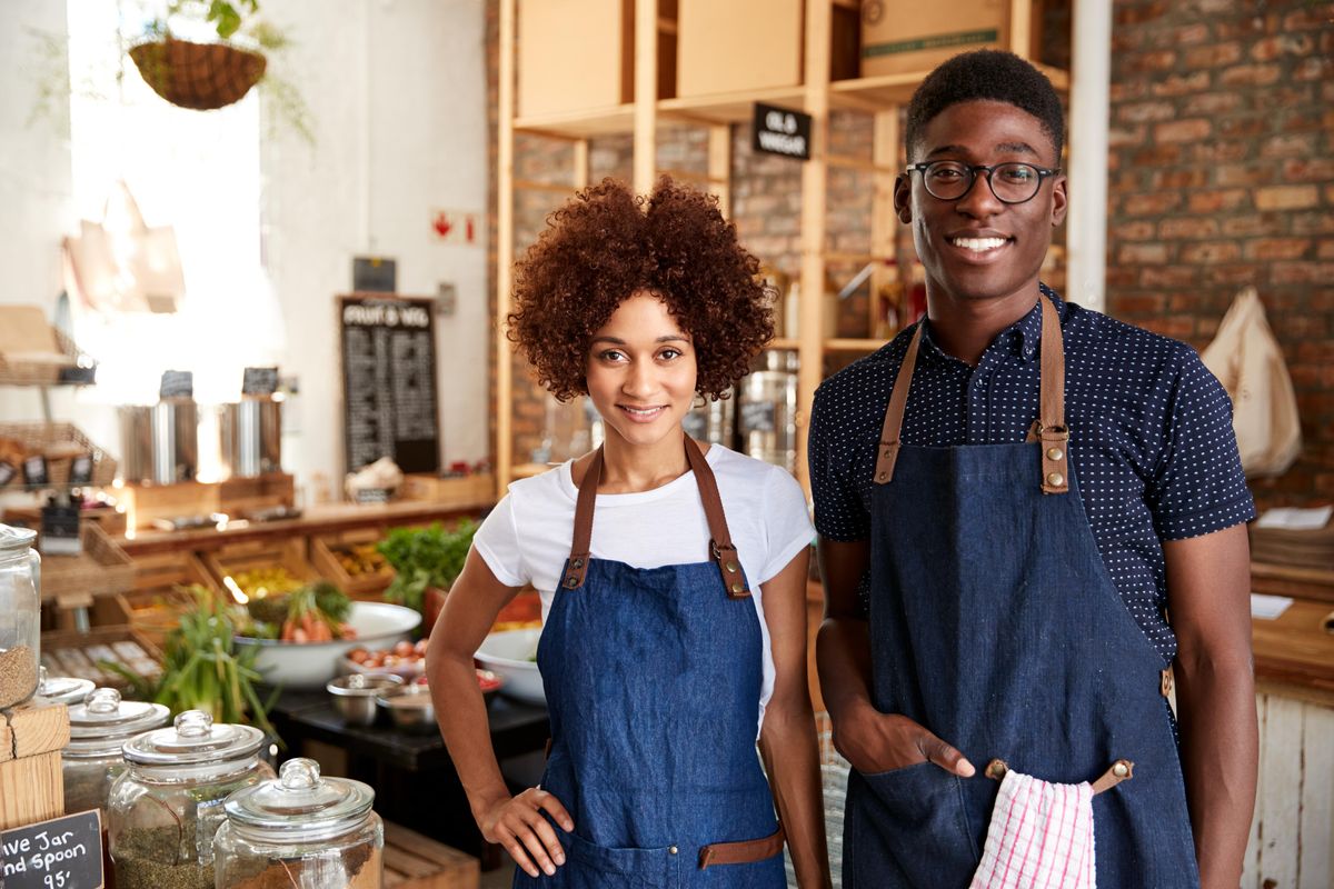 Business owners at a shop smiling.