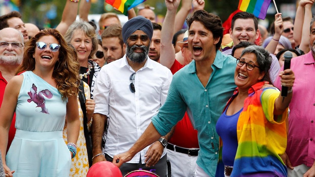 Canada's Prime Minister Justin Trudeau reacts as he and his wife Sophie Grégoire Trudeau (the two are now separated) walk in the Vancouver Pride Parade in Vancouver, British Columbia, on July 31, 2016.