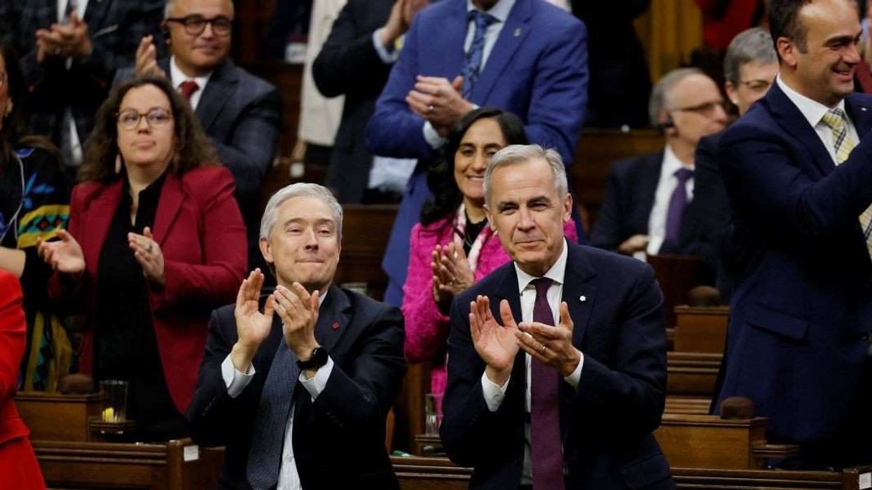 Canada's Prime Minister Mark Carney and Minister of Finance Francois-Philippe Champagne applaud after a confidence vote on the federal budget passes in the House of Commons on Parliament Hill in Ottawa, Ontario, Canada November 17, 2025.