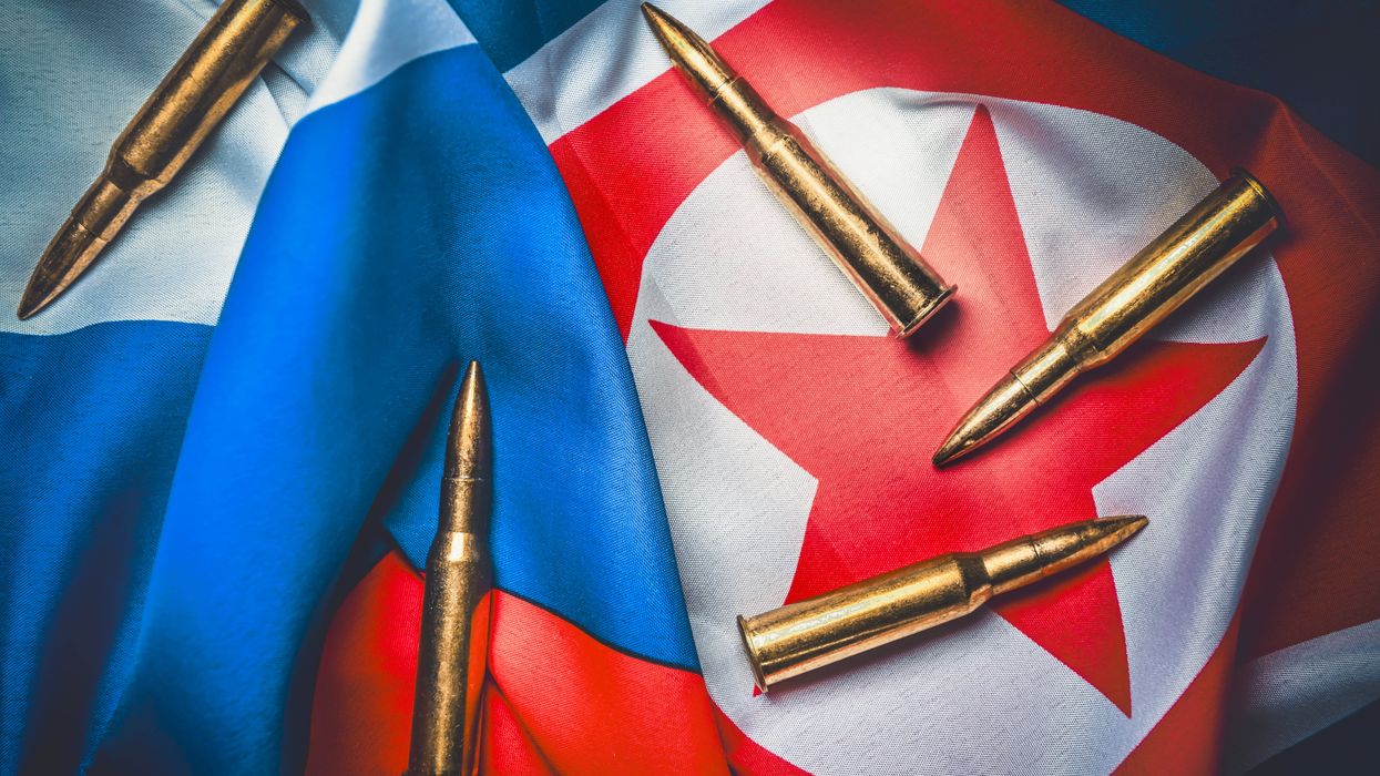 Cartridges lie on the flags of Russia and North Korea. 