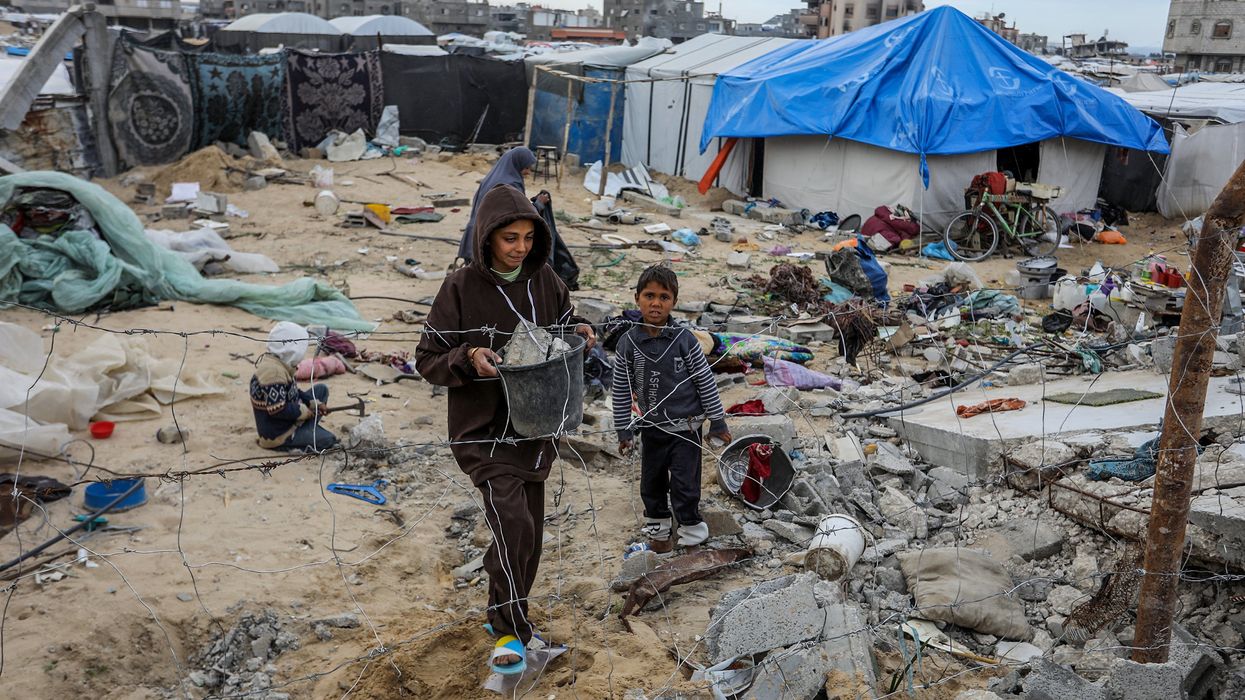 Children walk through the destruction, as Palestinians try to build