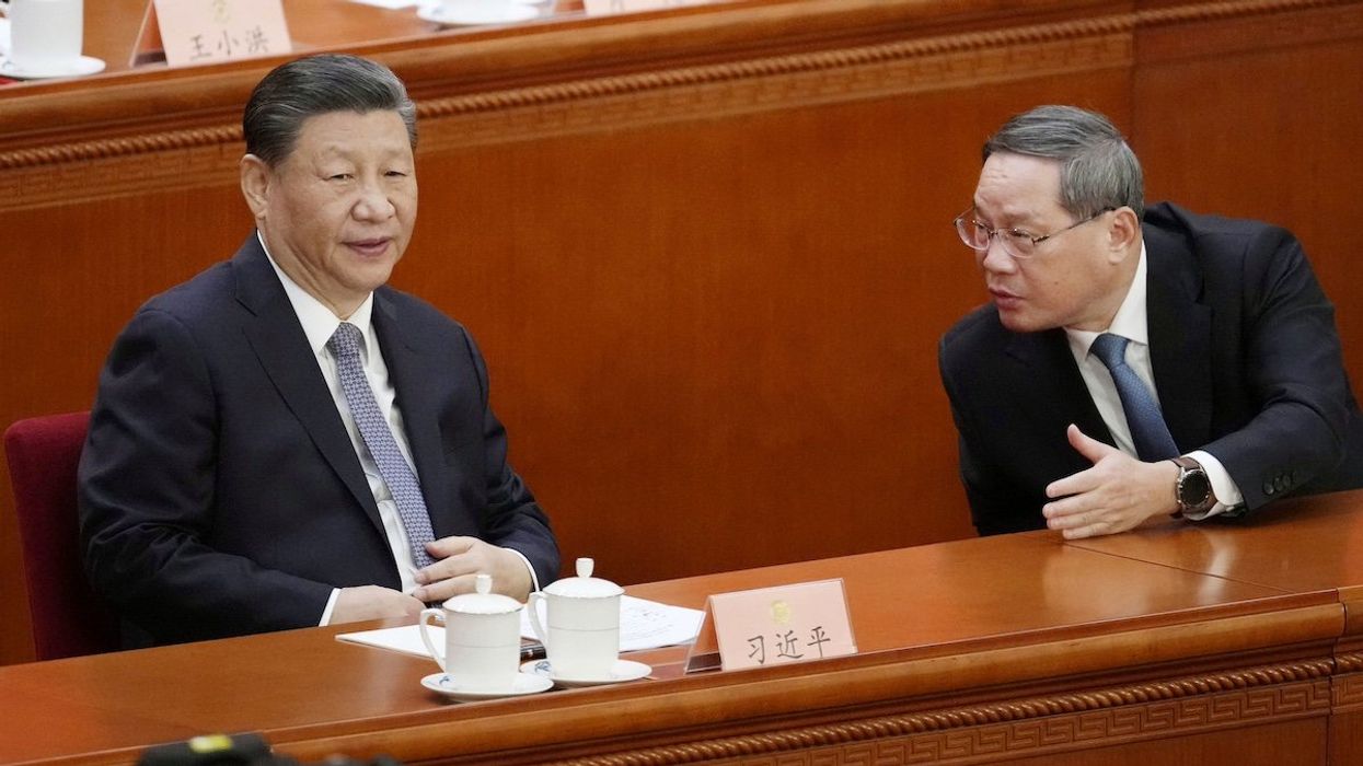 Chinese President Xi Jinping (L) converses with Premier Li Qiang on the first day of a weeklong meeting of the Chinese People's Political Consultative Conference, China's top political advisory body, at the Great Hall of the People in Beijing on March 4, 2024.