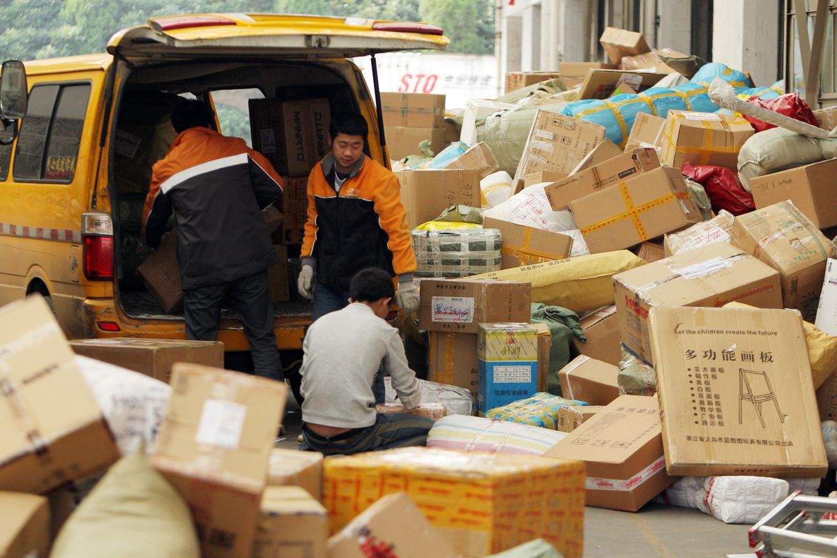 Chinese workers load a van with parcels, most of which are from online shopping, at a distribution center in Shanghai.