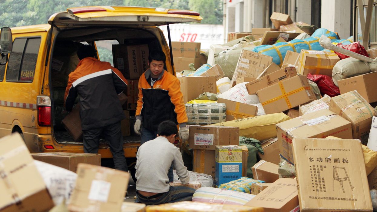 Chinese workers load a van with parcels, most of which are from online shopping, at a distribution center in Shanghai.