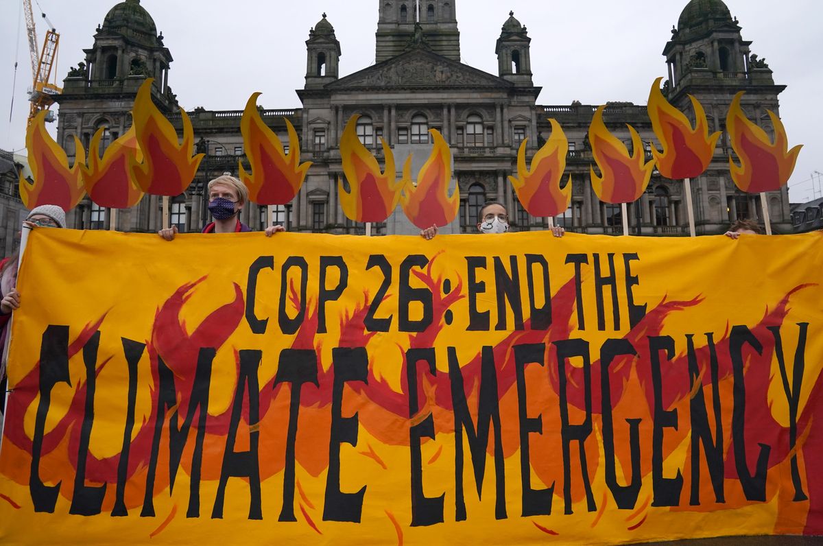 Climate activists "set fire" to George Square, Glasgow, with an art installation of faux flames, smoke, and banners, and giant fire extinguishers, creating a field of climate fire to welcome world leaders to Glasgow for the Cop26 conference.