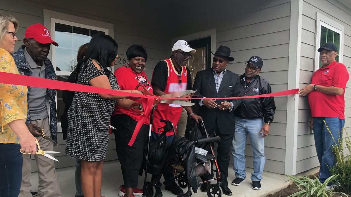 Community residents gathering to greet a man.