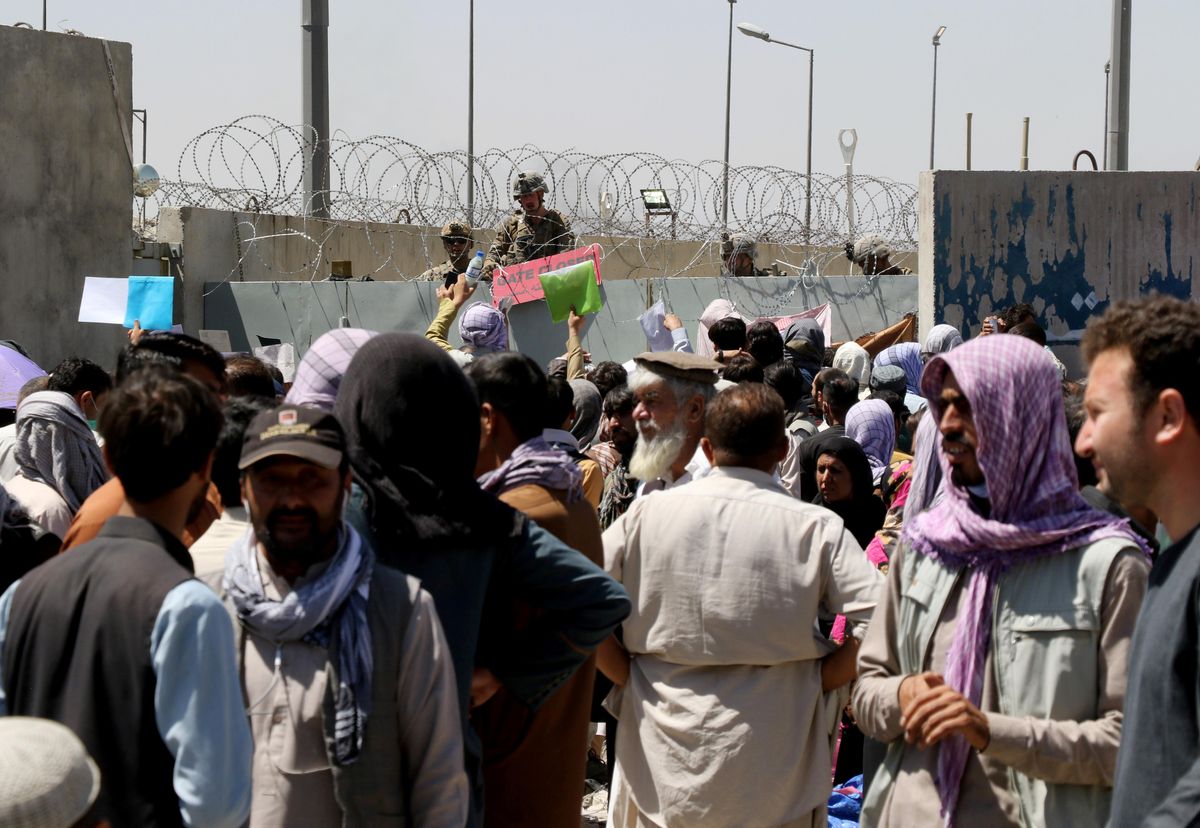 Crowds of people show their documents to U.S. troops outside the airport in Kabul, Afghanistan August 26, 2021.