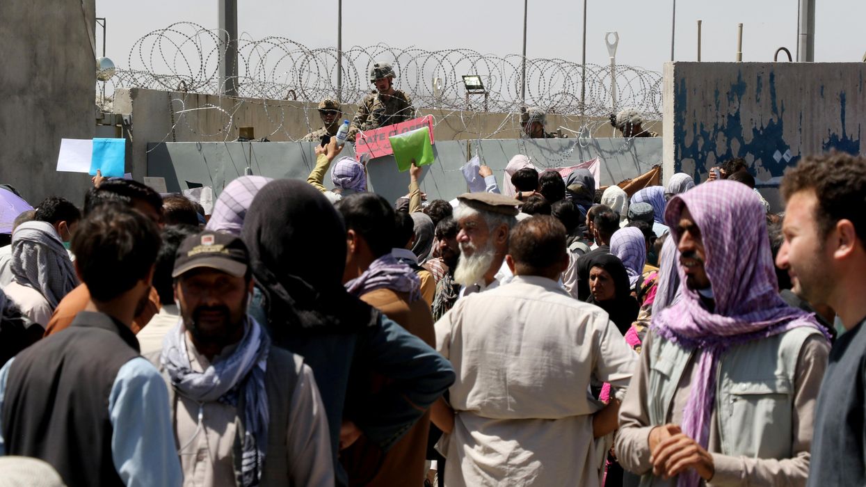 Crowds of people show their documents to U.S. troops outside the airport in Kabul, Afghanistan August 26, 2021.