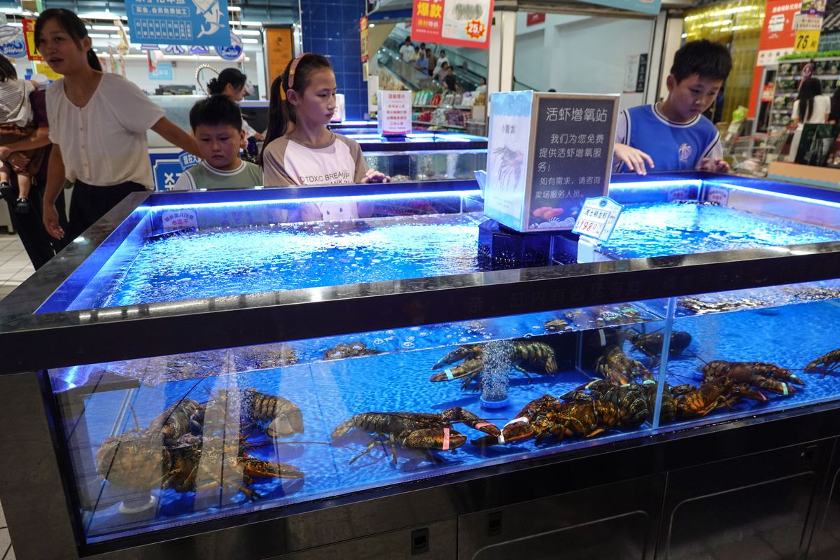 Customers prepare to buy seafood at a supermarket in Fuyang city, East China's Anhui province