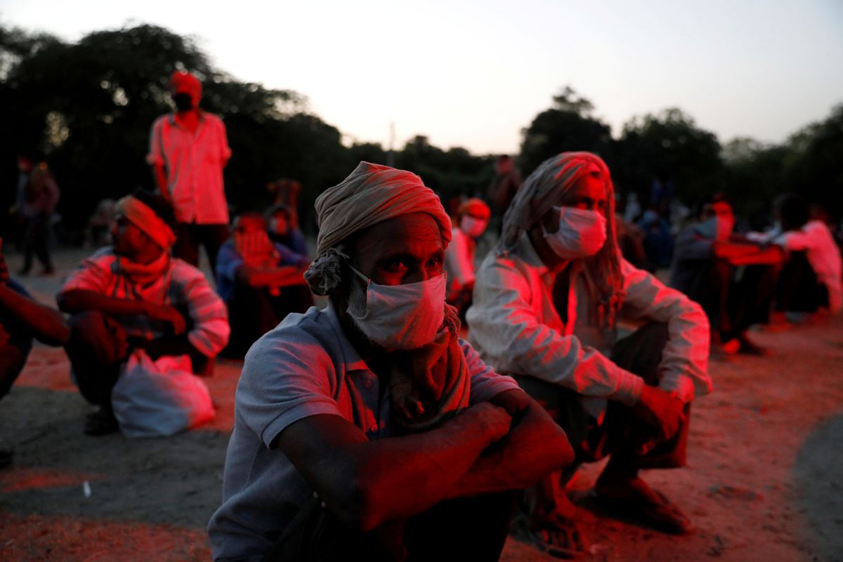 Daily wage workers and homeless people wearing face masks on the banks of Yamuna river in India. Reuters