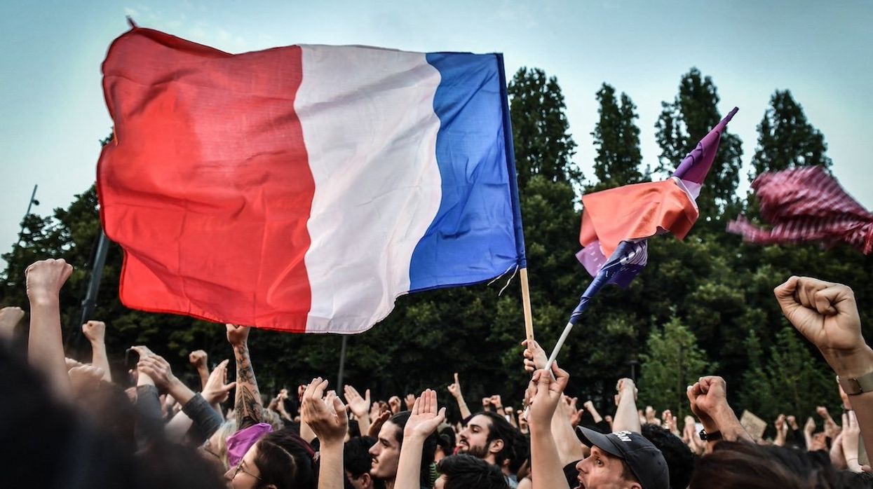 Demonstrators celebrate during the New Popular Front’s election night after announcing the voting primary results for 2nd tour of the French legislative elections, in Paris on July 7, 2024.
