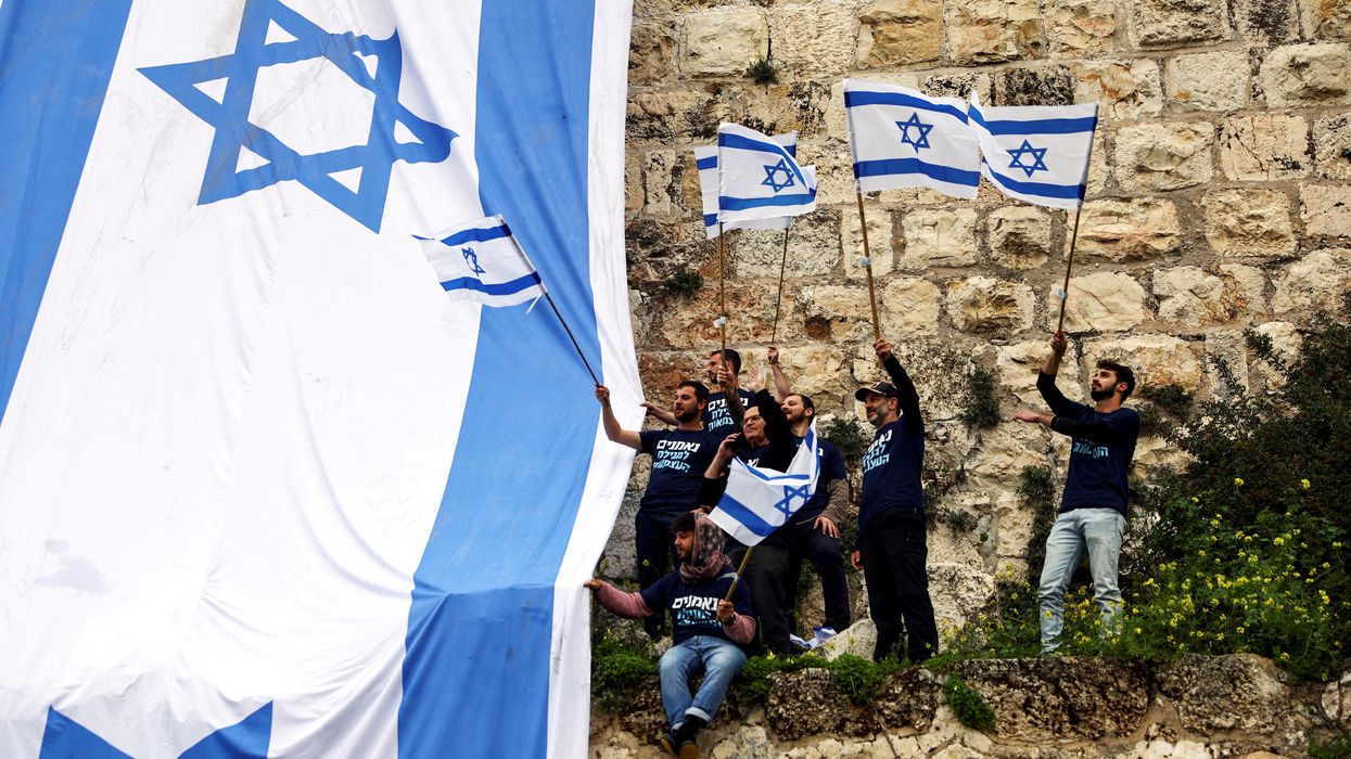 Demonstrators drape the national flag of Israel on the walls of Jerusalem's Old City.