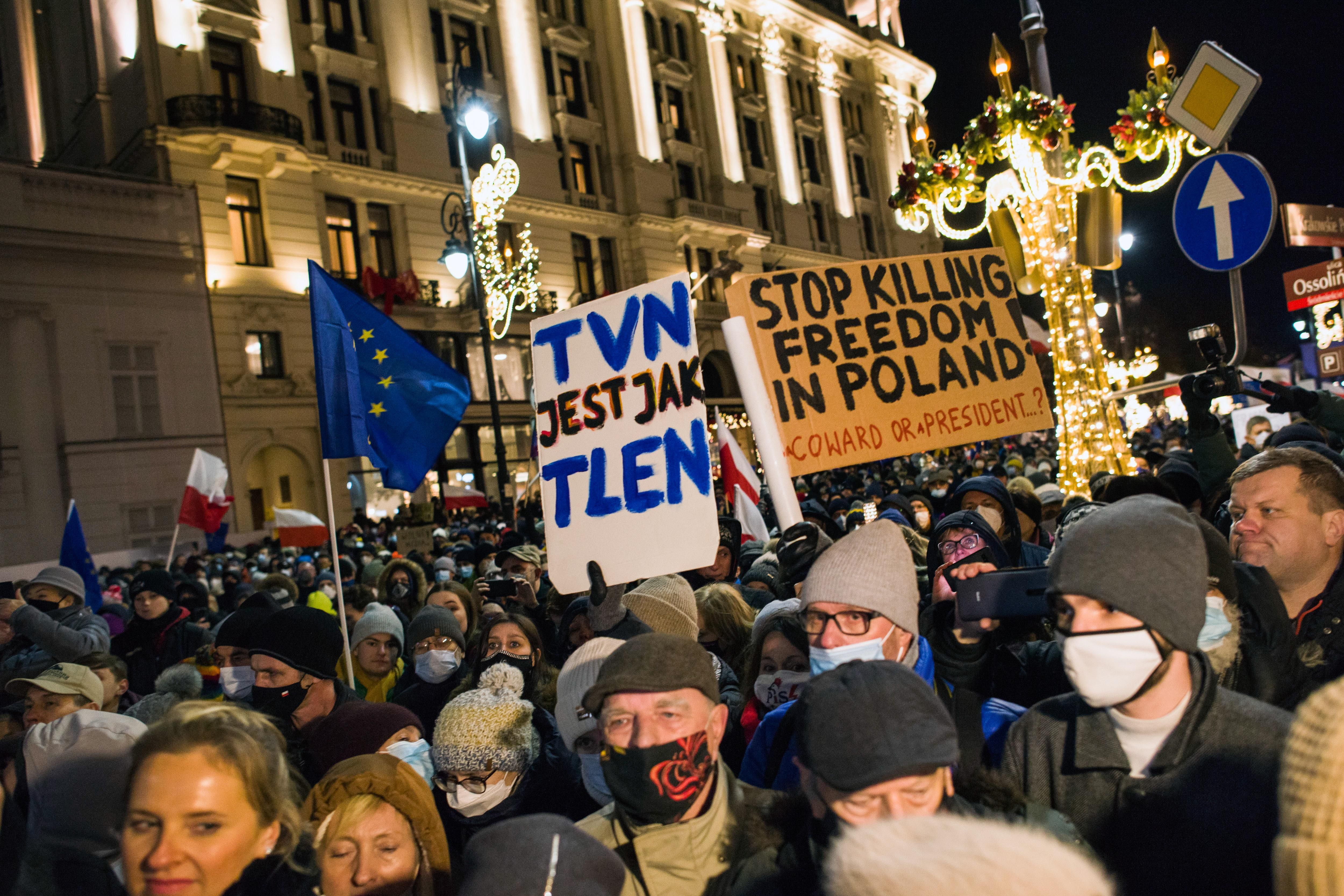 Demonstrators hold placards and flags during the demonstration. Thousands of people came to the presidential palace in Warsaw to protest against restrictions of media freedom by the Polish government