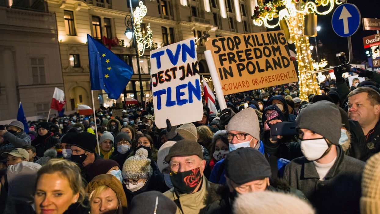 Demonstrators hold placards and flags during the demonstration. Thousands of people came to the presidential palace in Warsaw to protest against restrictions of media freedom by the Polish government