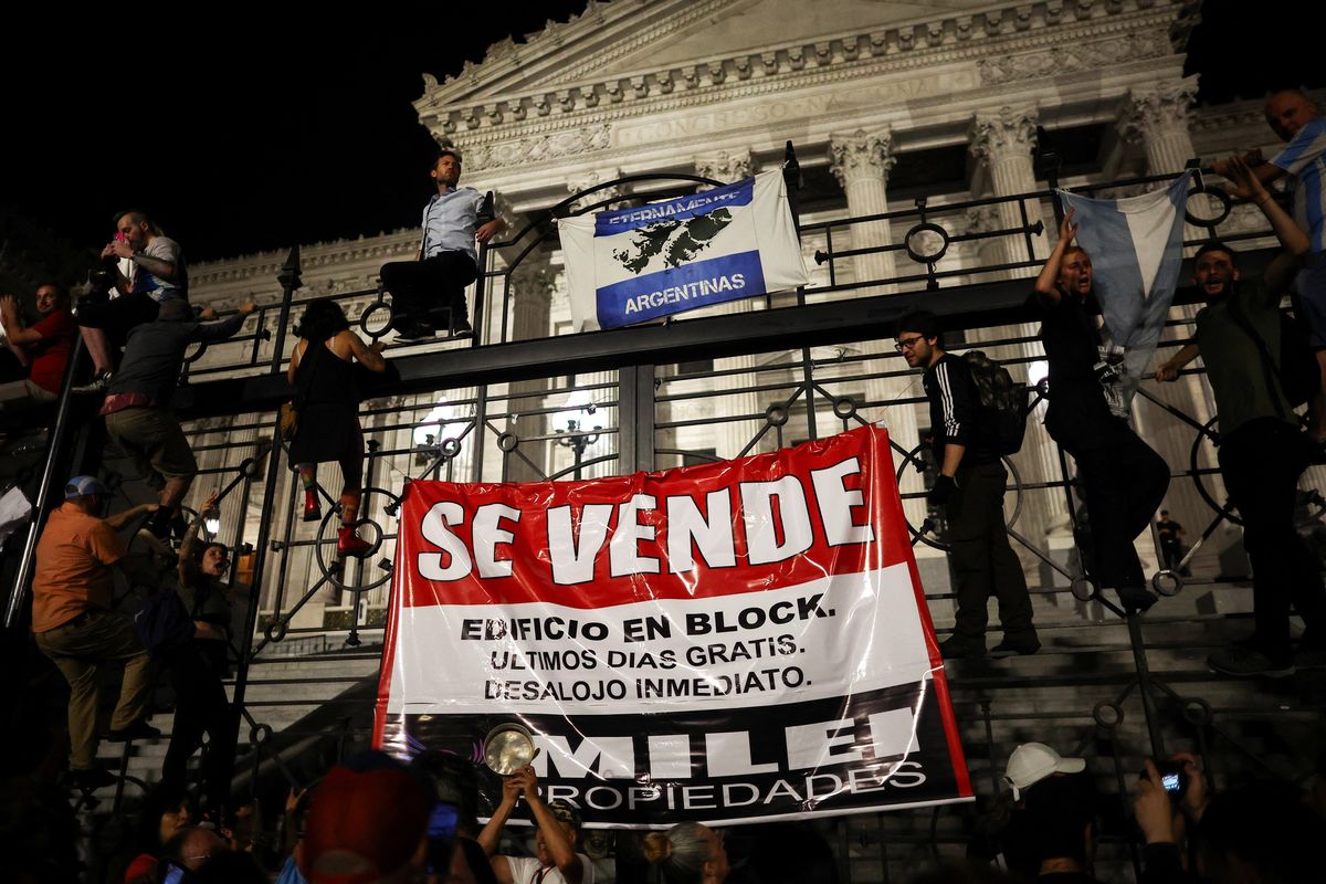 ​Demonstrators protest against Argentina's new President Javier Milei's adjustment policy, outside the National Congress in Buenos Aires, Argentina December 21, 2023. The banner reads, "For Sale". 