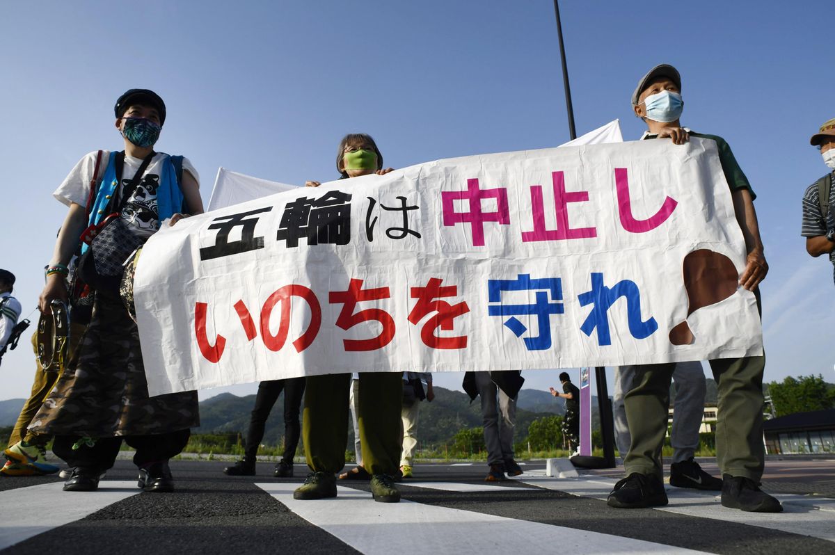 Demonstrators stage a protest in front of Sanga Stadium in the Kyoto Prefecture city of Kameoka, western Japan, on May 25, 2021, against the Tokyo Olympics amid the coronavirus pandemic. The Olympic torch relay was held inside the stadium the same day