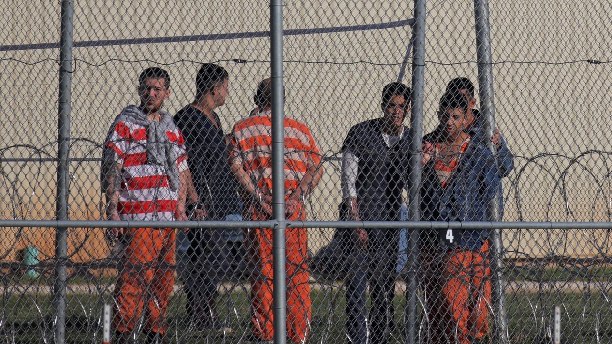 Detainees stand behind a fence at the Bluebonnet Detention Facility, where Venezuelans at the center of a Supreme Court ruling on deportation are held, in Anson, Texas, U.S. April 22, 2025.