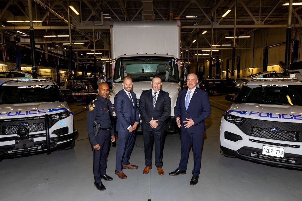 Detectives pose in front of the truck used in the Toronto Pearson International Airport gold heist as they give details of the arrests made one year on in Brampton, Ontario, on April 17, 2024. 