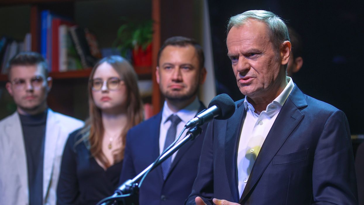 Donald Tusk, the chairman of the Civic Platform (PO) opposition party, surrounded by party members, speaks during a press conference in Krakow.