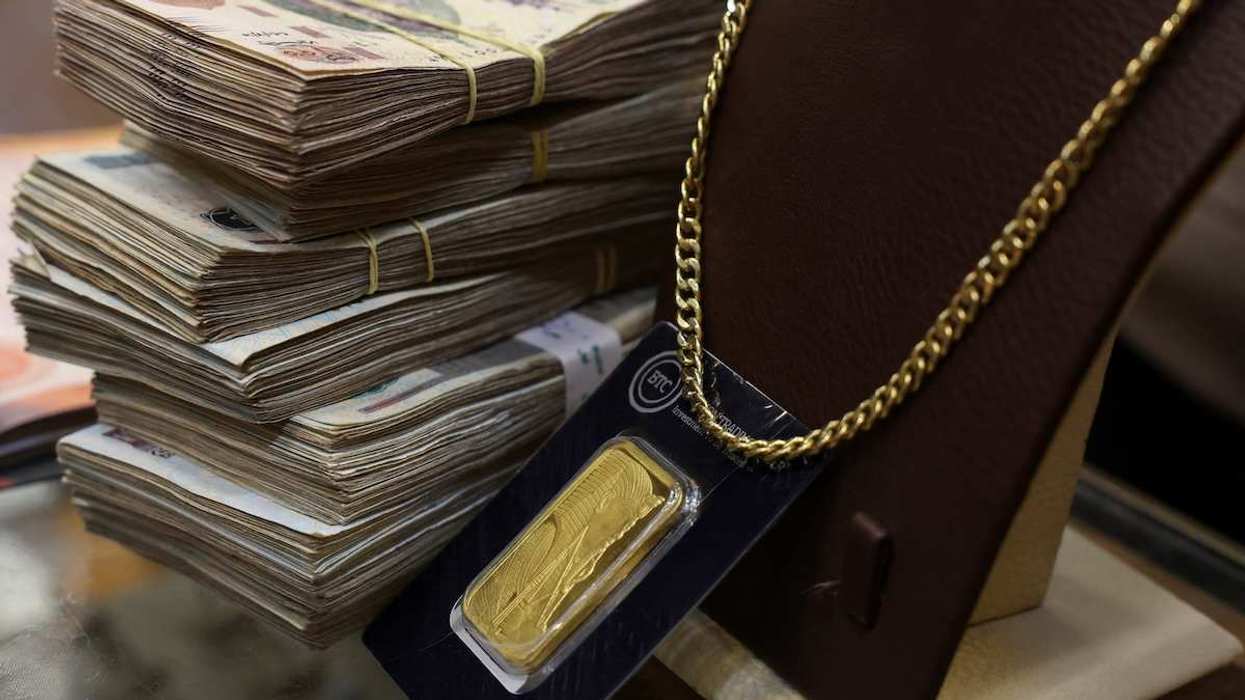 Egyptian pounds, a gold bar and a necklace are seen during an interview with Mohamed Abdeen, an Egyptian jeweller, in Cairo, Egypt, on February 5, 2026.