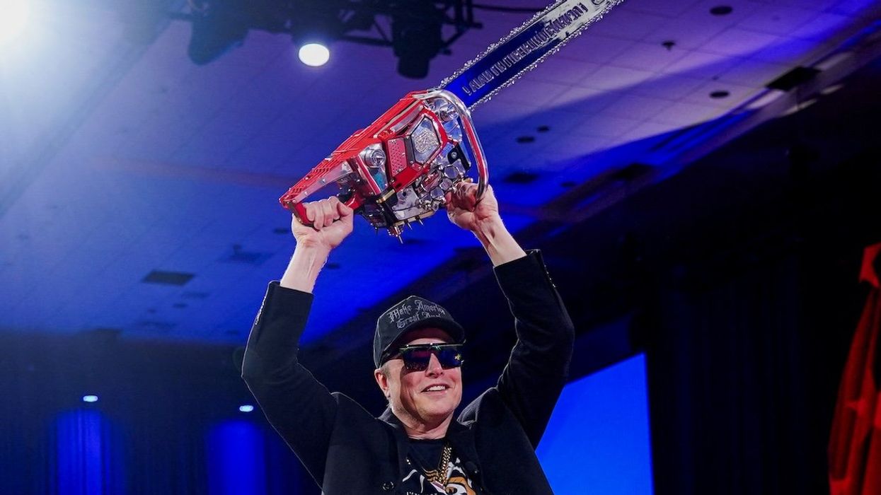 Elon Musk holds a chainsaw onstage as he attends the Conservative Political Action Conference in National Harbor, Maryland, on Feb. 20, 2025. The idea is that he's taking a chainsaw to the federal bureaucracy.